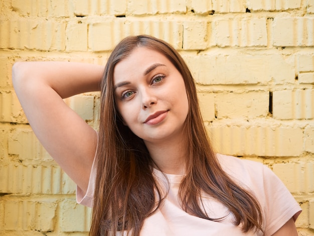 Mujer joven rubia en una camiseta rosa