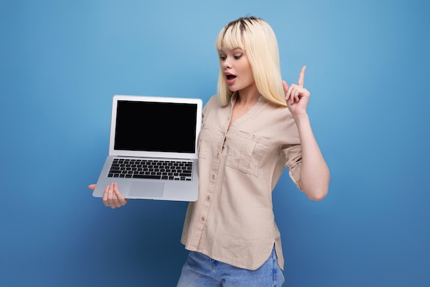 Mujer joven rubia freelance con computadora portátil
