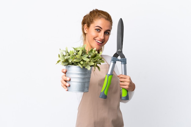 Foto mujer joven rubia jardinero sobre pared blanca aislada