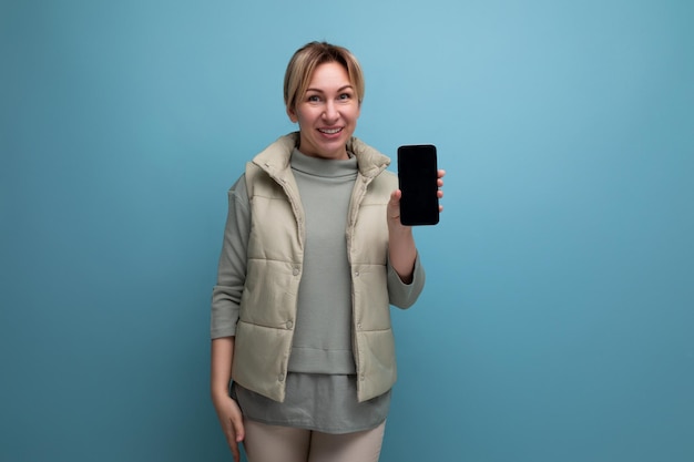 Mujer joven rubia mostrando maqueta de teléfono inteligente