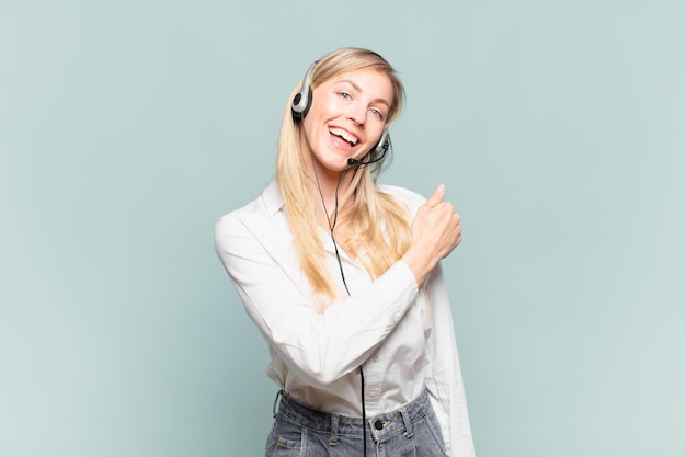 Mujer joven rubia telemarketing que se siente feliz, positiva y exitosa, motivada cuando enfrenta un desafío o celebra buenos resultados