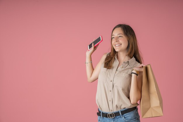 Mujer joven saludando con su bolsa de compras del día.