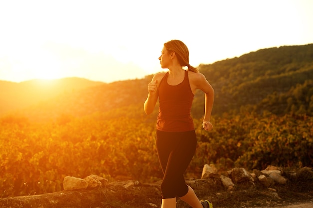 Mujer joven sana trotar al aire libre en la naturaleza