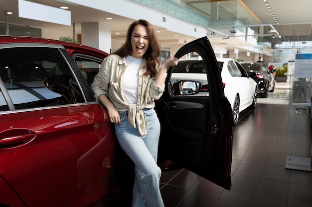 Mujer joven satisfecha después de que le aprobaran un préstamo para comprar un auto nuevo