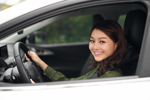 Mujer joven seductora conduciendo el coche y sonriendo