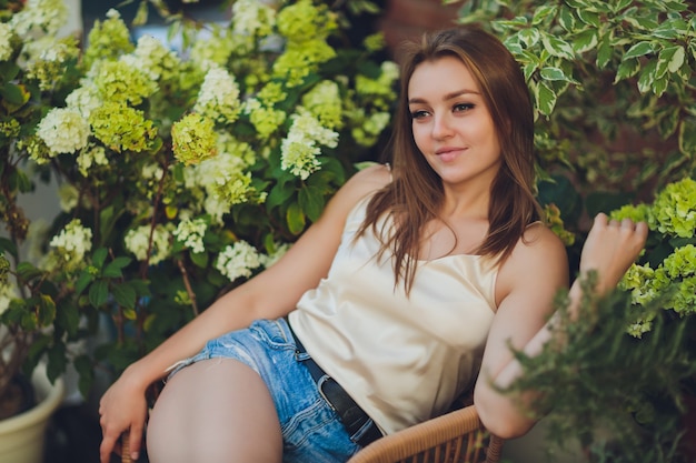 Mujer joven seleccionando flores en el mercado de las flores o en la tienda en un día de verano.