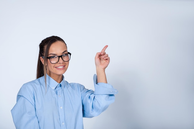 mujer joven, señalar hacia arriba, con, dedo, y, sonriente