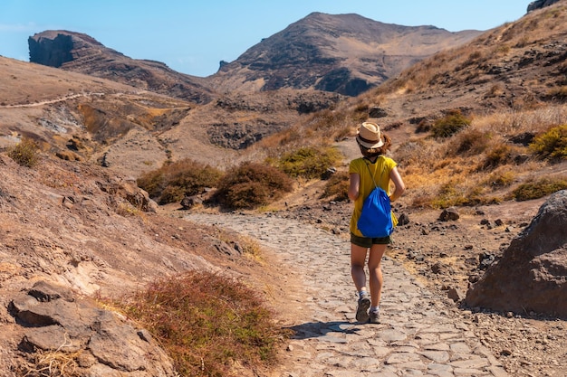 Una mujer joven en un sendero de trekking en la costa de Ponta de Sao Lourenco Madeira