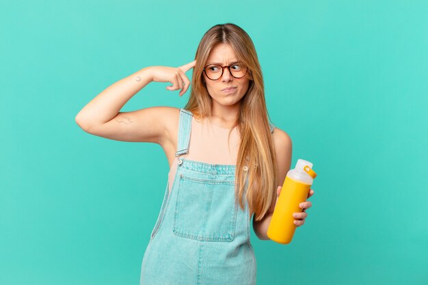 Mujer joven con una sensación de batido confundida y perpleja, mostrando que estás loco