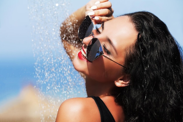 Mujer joven sensual que se relaja en la piscina del balneario al aire libre