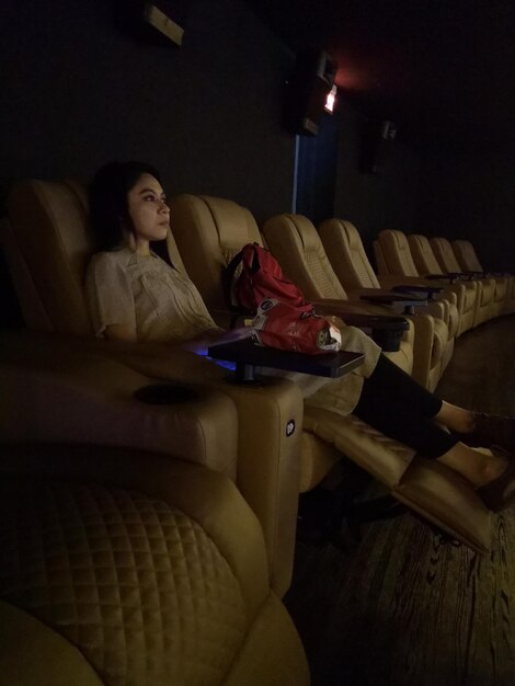 Foto mujer joven sentada en un asiento en el teatro