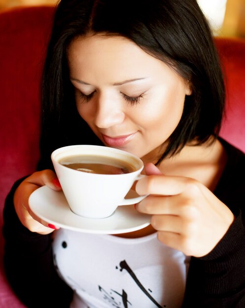 Mujer joven sentada en una cafetería tomando café