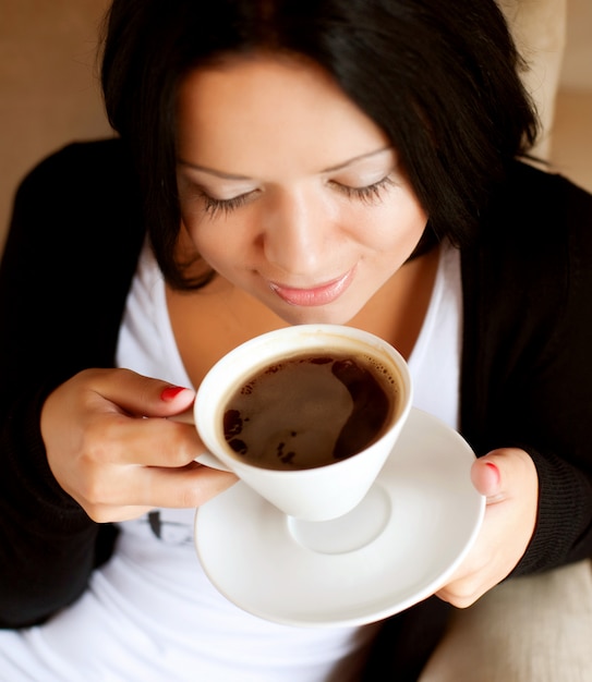 Mujer joven sentada en una cafetería tomando café