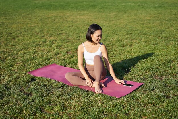 Foto mujer joven sentada en el campo de hierba