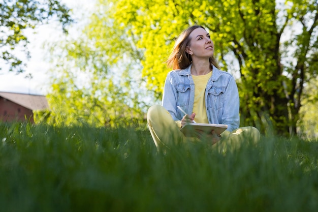 Foto mujer joven sentada en el campo