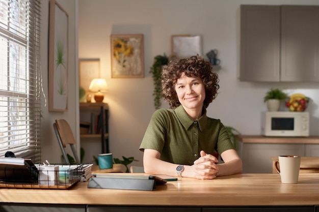 Mujer joven sentada en la cocina