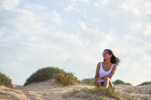 Mujer joven sentada en las dunas