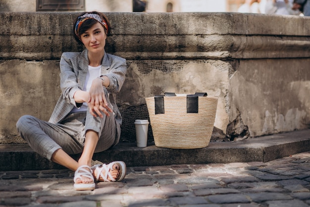 Mujer joven sentada junto a la fuente