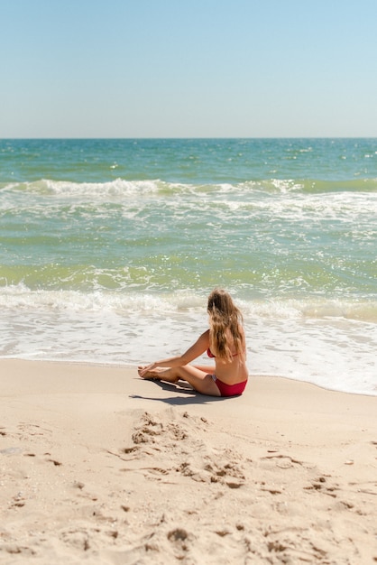 mujer joven sentada en la playa