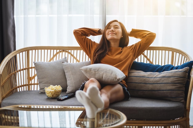 Foto mujer joven sentada en el sofá en casa