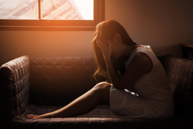 Mujer joven sentada en el sofá en casa