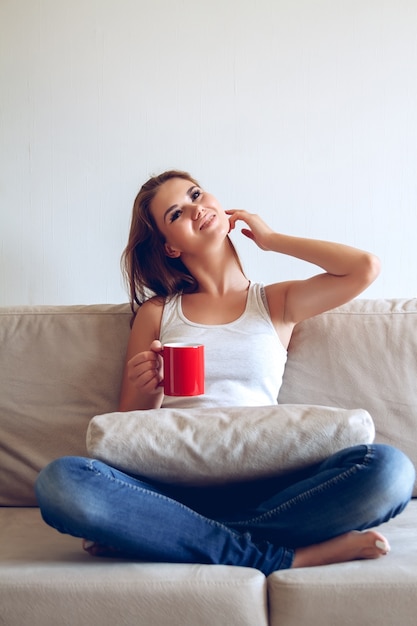 Mujer joven sentada en el sofá