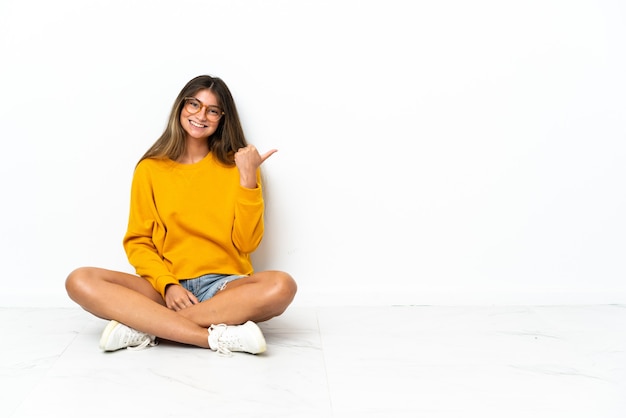 Mujer joven sentada en el suelo aislado