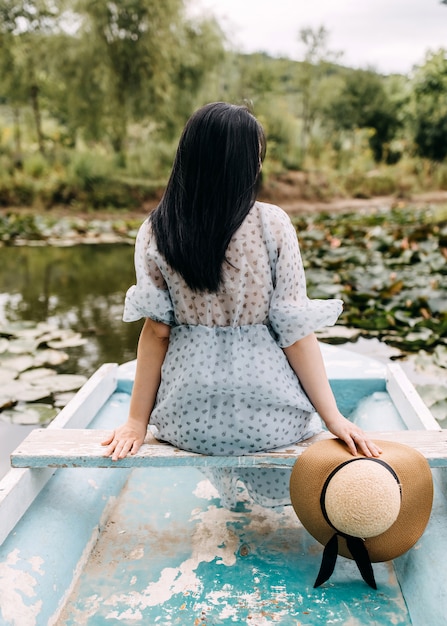 Mujer joven, sentado, en, barco, en el lago