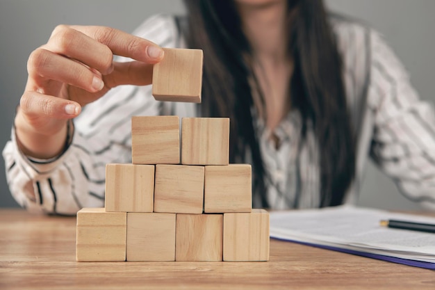 mujer joven, sentado, delante de, un, pirámide, de, cubos