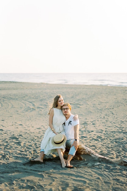 mujer joven, sentado, en, hombre, regazo, en la playa