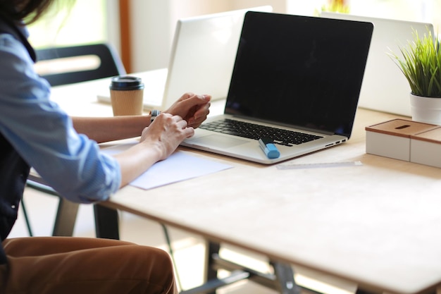 mujer joven, sentado, en, mesa de la oficina, con, computador portatil