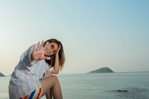 Mujer joven, sentado, en, el, roca, en la playa