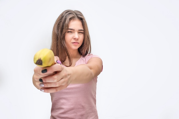 Mujer joven seria sostener plátano como arma.