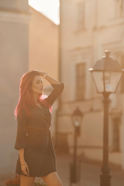 Foto mujer joven sexy con un cuerpo delgado y perfecto y cabello rosado con un vestido corto caminando por la calle en el...
