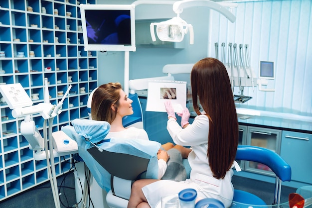 Mujer joven en la silla del dentista durante un procedimiento dental Resumen de la prevención de la caries dental