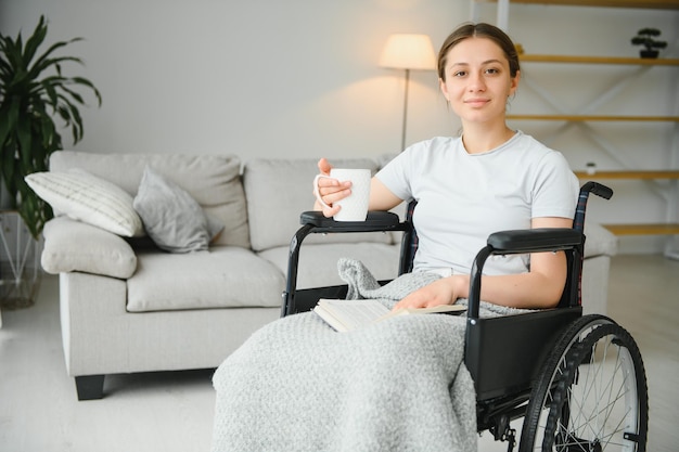 Mujer joven en silla de ruedas en casa