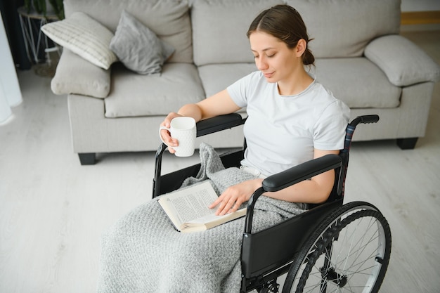 Mujer joven en silla de ruedas en casa