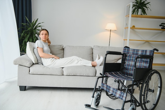 Foto mujer joven en silla de ruedas en casa