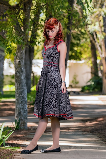 Mujer joven con un simple vestido de primavera posando en el parque