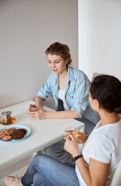 Mujer joven sintiendo felicidad mientras pasa su fin de semana en casa con su mejor amiga