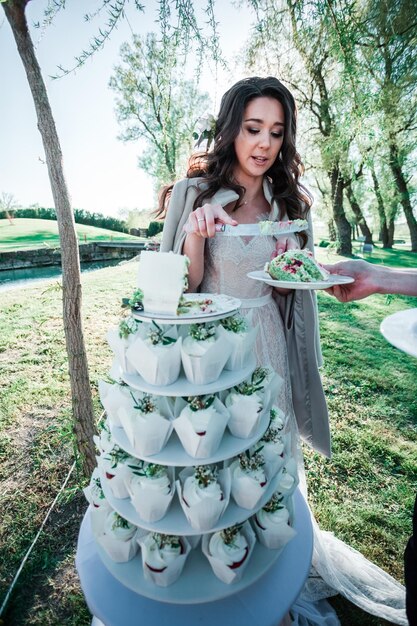 Foto mujer joven sirviendo una rebanada de pastel en el parque