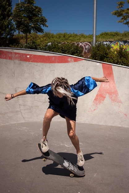 Mujer joven skateboarding en skatepark