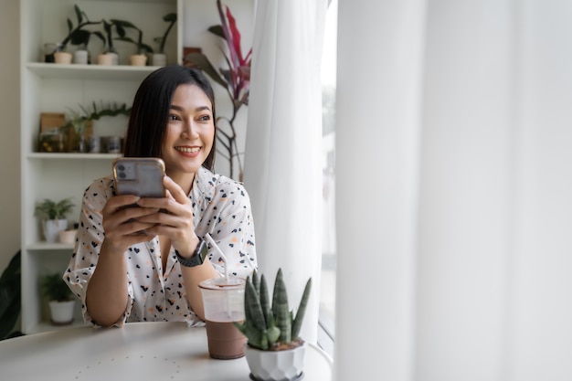 Mujer joven con smartphone en café