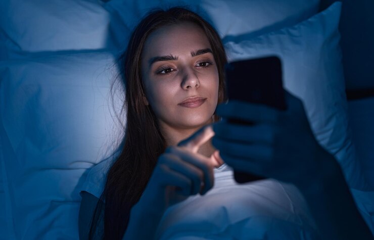 Foto mujer joven con smartphone en la cama