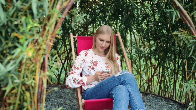 Mujer joven con smartphone en gazebo de planta.