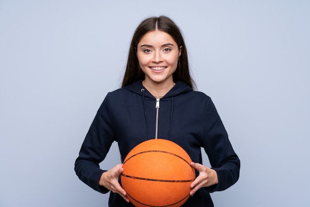 Mujer joven sobre aislado con pelota de baloncesto