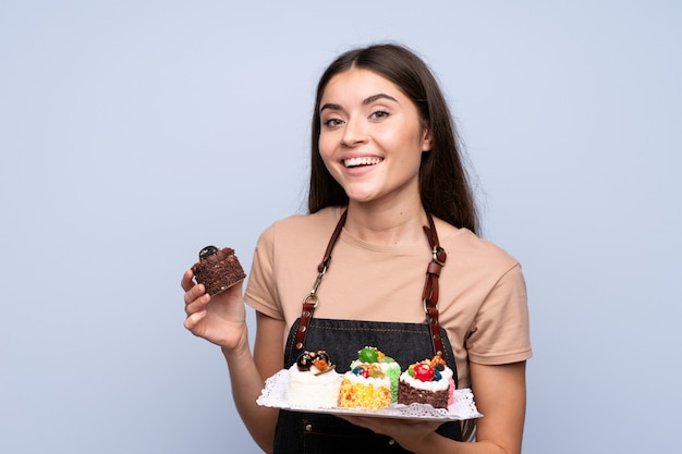 Mujer joven sobre aislado sosteniendo mini tortas