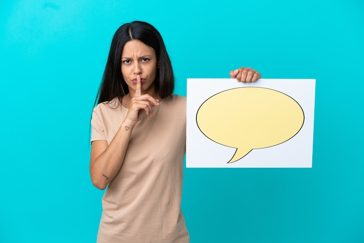 Foto mujer joven sobre fondo aislado sosteniendo un cartel con el icono de la burbuja del discurso haciendo gesto de silencio