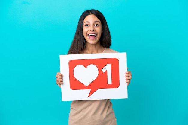 Foto mujer joven sobre fondo aislado sosteniendo una pancarta con icono como con expresión feliz