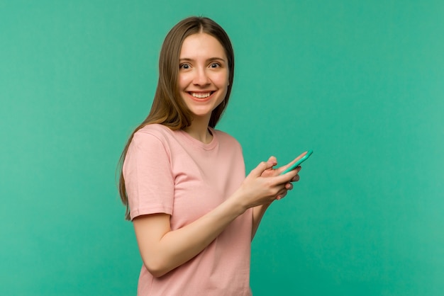 Mujer joven sobre fondo azul aislado sorprendido y enviando un mensaje